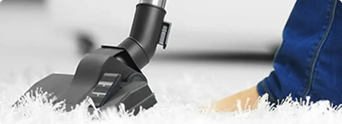 Close-up of a professional vacuuming a white carpet in Mechanicsville.